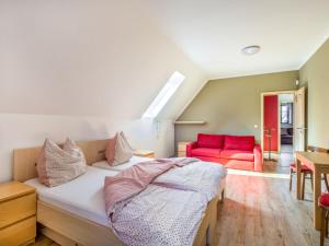 1 dormitorio con 1 cama y 1 sofá rojo en Apartment Na mechu-2 by Interhome, en Mezná