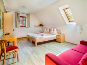 1 dormitorio con cama, escritorio y sofá en Apartment Na mechu-2 by Interhome, en Mezná