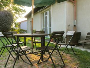 a table with chairs and an umbrella in front of a house at Holiday Home Milovice by Interhome in Milovice