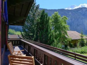 a balcony with two chairs and a view of a mountain at Chalet Chalet am Schärm by Interhome in Lauterbrunnen
