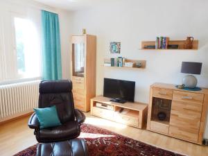 a living room with a chair and a television at Apartment Maier-2 by Interhome in Triberg +13 photos