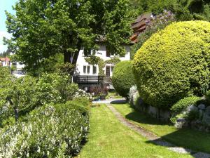 トリベルクにあるApartment Maier-2 by Interhomeの茂みと木々の庭園のある家
