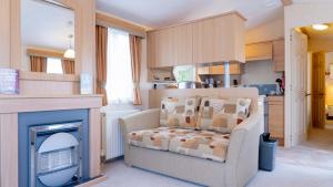 a living room with a chair and a fireplace at Newby Bridge Country Caravan Park in Newby Bridge