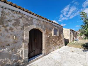 an old stone building with a black door at Il Casale Suite&Rooms in Burgio