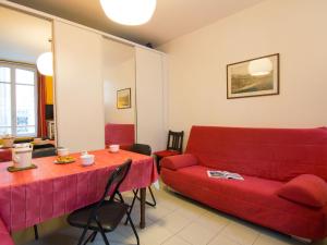 トゥルヴィル・シュル・メールにあるApartment Bonsecours by Interhomeのリビングルーム(赤いソファ、テーブル付)