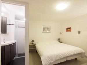 トゥルヴィル・シュル・メールにあるApartment Bonsecours by Interhomeの白いベッドルーム(ベッド1台、シンク付)