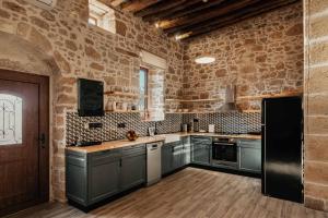 kuchnia z szarymi szafkami i ceglaną ścianą w obiekcie La casa dell'arch w mieście Charaki