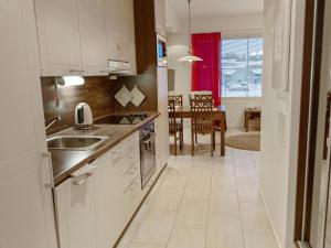 a kitchen with white appliances and a dining room at Holiday Home Yllästar 3 as 509 by Interhome in Äkäslompolo