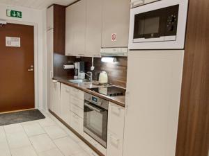 a kitchen with white cabinets and a microwave at Holiday Home Yllästar 3 as 509 by Interhome in Äkäslompolo