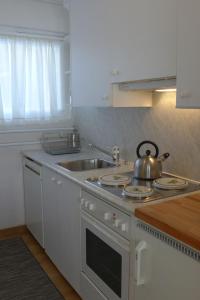 a kitchen with a sink and a tea kettle on a stove at Apartment Chesa Cripels I by Interhome in St. Moritz