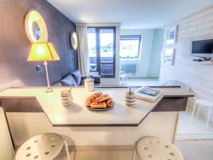 a kitchen with a table with a plate of donuts on it at Studio Les Marinas-10 by Interhome in Deauville +13 photos
