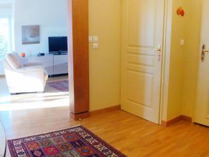 Una habitación con una puerta y una sala de estar con una alfombra. en Apartment Elisa-2 by Interhome, en Trouville-sur-Mer