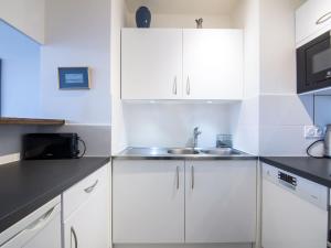a kitchen with white cabinets and a sink at Apartment Les Marinas-3 by Interhome in Deauville