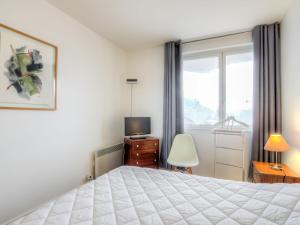 a bedroom with a bed and a tv and a window at Apartment Les Marinas-3 by Interhome in Deauville