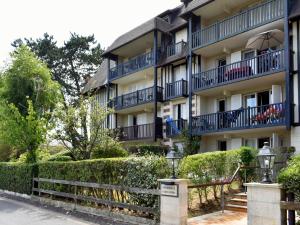 an apartment building with blue balconies and bushes at Apartment Eden Park by Interhome in Bénerville-sur-Mer