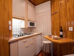 uma cozinha com um lavatório e um balcão com uma garrafa de vinho em Studio Le Curling B - Val Claret-36 by Interhome em Tignes