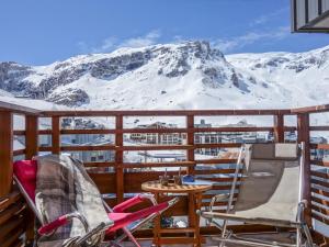 balcón con sillas, mesa y montañas cubiertas de nieve en Apartment Le Curling B - Val Claret-35 by Interhome en Tignes