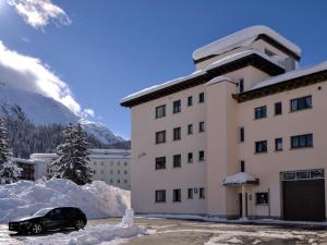un coche aparcado frente a un edificio con nieve en Apartment Chesa La Soliva by Interhome, en St. Moritz