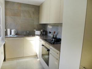 eine Küche mit weißen Schränken und einem Waschbecken in der Unterkunft Apartment Chesa La Soliva by Interhome in St. Moritz