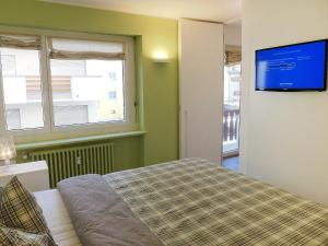 1 dormitorio con 1 cama y TV en la pared en Apartment Chesa La Soliva by Interhome, en St. Moritz
