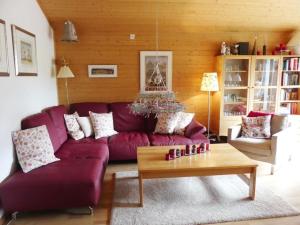 a living room with a purple couch and a table at Apartment Kristall by Interhome in Zweisimmen