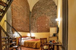 a bedroom with a bed in a brick wall at Hotel Alba Palace in Florence