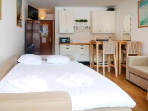 ein Schlafzimmer mit einem weißen Bett und einer Küche in der Unterkunft Studio Rosablanche D12 by Interhome in Siviez + 14 Fotos