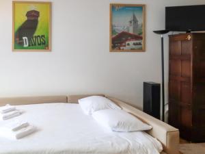 a bedroom with a bed with two posters on the wall at Studio Rosablanche D12 by Interhome in Siviez +14 photos