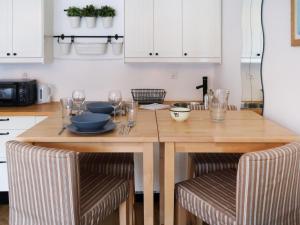 eine Küche mit einem Holztisch mit Tellern und Weingläsern in der Unterkunft Studio Rosablanche D12 by Interhome in Siviez