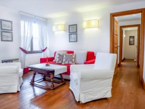 a living room with a red couch and white chairs at Apartment Chesa Sonnalpine B 52 by Interhome in St. Moritz