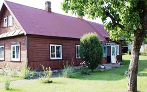 a wooden house with a red roof at Pokoje Przy Stoczku in Białowieża