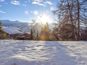 ein schneebedecktes Feld mit der Sonne im Hintergrund in der Unterkunft Studio Diure 0113 by Interhome in Verbier