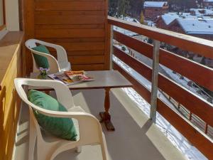 - Balcón con vistas, mesa y 2 sillas en Apartment Bruyères A32 by Interhome, en Verbier