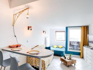 uma sala de estar com uma mesa e um sofá em Studio Les Marinas-8 by Interhome em Deauville