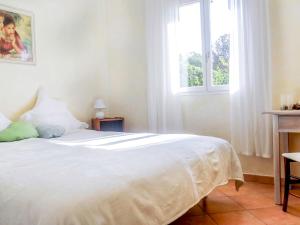 sypialnia z białym łóżkiem i oknem w obiekcie Apartment Village Marin-16 by Interhome w mieście La Foux