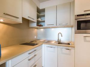 eine Küche mit weißen Schränken und einem Waschbecken in der Unterkunft Studio Les Trois Iles-2 by Interhome in Port-Haliguen