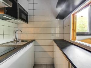 Elle comprend une petite cuisine avec un évier et une fenêtre. dans l'établissement Apartment Les Tommeuses - Val Claret-32 by Interhome, à Tignes