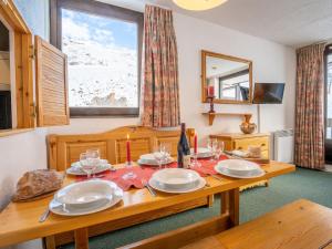 a dining room with a table with plates and wine glasses at Apartment Les Tommeuses - Val Claret-32 by Interhome in Tignes