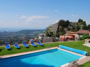 una piscina con sillas azules y vistas en Villa Vista da Rocca di Papa-1 by Interhome, en Rocca di Papa