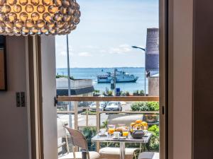 a table with drinks on a balcony with a view of the water at Apartment Les Néréïdes-1 by Interhome in Quiberon