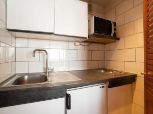 a small kitchen with a sink and a microwave at Studio Le Slalom - Val Claret-7 by Interhome in Tignes