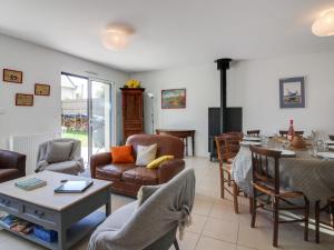 ein Wohnzimmer mit Sofas und einem Tisch und Stühlen in der Unterkunft Holiday Home Ker-Heol by Interhome in Port Blanc