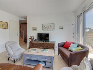 a living room with a couch and a tv at Holiday Home Ker-Heol by Interhome in Port Blanc