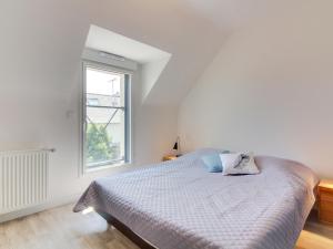 ein weißes Schlafzimmer mit einem Bett und einem Fenster in der Unterkunft Holiday Home Ker-Heol by Interhome in Port Blanc + 14 Fotos