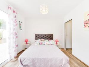 コゴランにあるHoliday Home Les Hautes Terres by Interhomeの白いベッドルーム(ピンクのランプ付きの大型ベッド1台付)