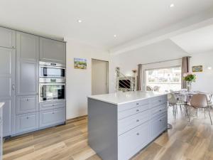 a kitchen with white cabinets and a table with chairs at Holiday Home Les Hautes Terres by Interhome in Cogolin +12 photos