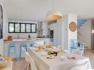 Saint-JulienにあるHoliday Home Les Pins du Rohu by Interhomeの白いテーブルと椅子、青をアクセントにしたキッチン