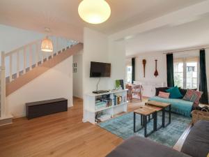 a living room with a blue couch and a tv at Holiday Home Pival by Interhome in Port Blanc