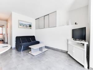 a living room with a couch and a flat screen tv at Apartment Les Marinas de la Plage I-3 by Interhome in Le Grau-du-Roi