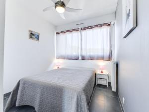 a white bedroom with a bed and a window at Apartment Les Marinas de la Plage I-3 by Interhome in Le Grau-du-Roi +12 photos
